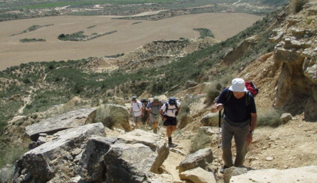 personas subiendo por una montana de piedra